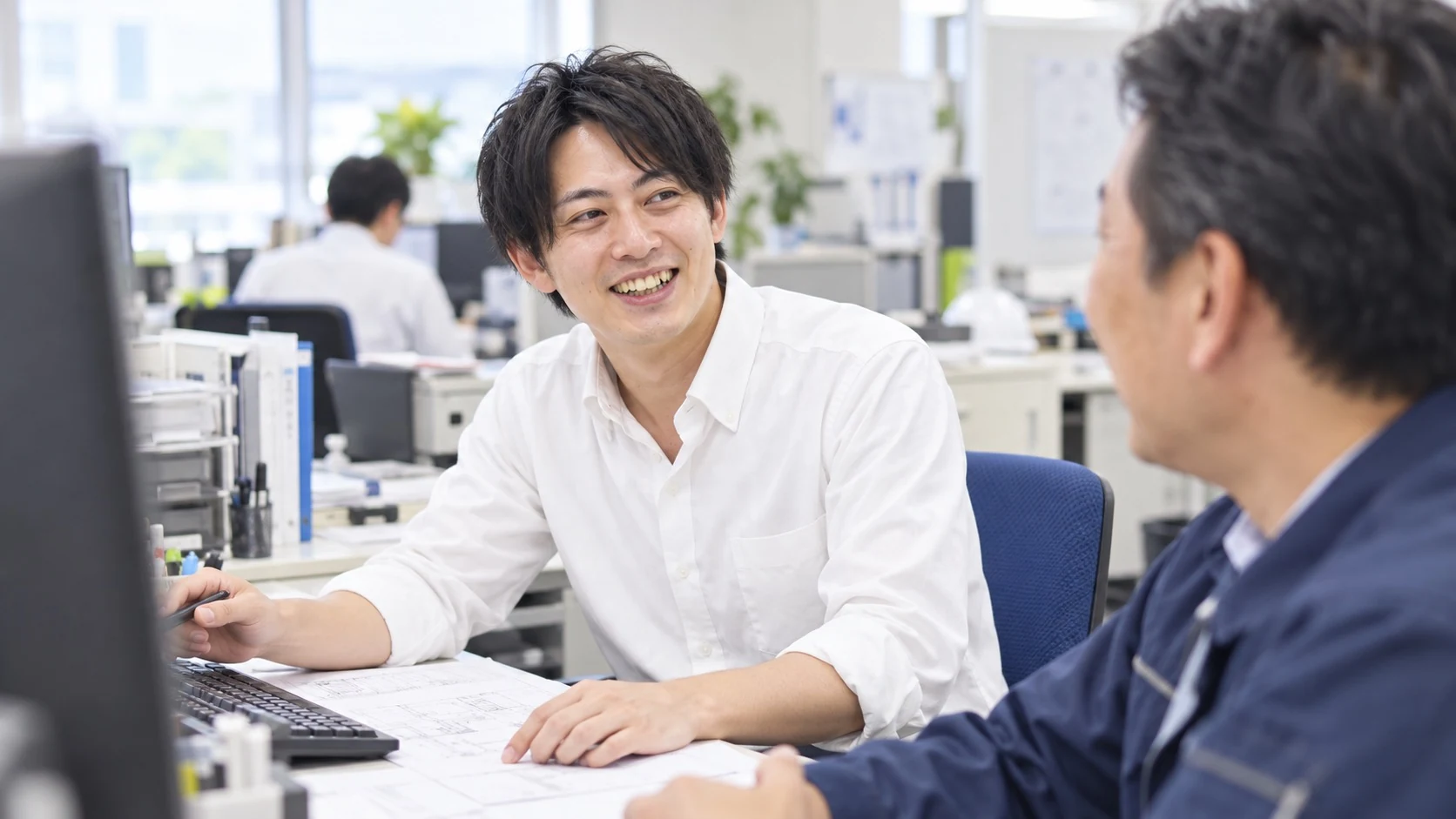事務所で笑顔で話す社員たち
