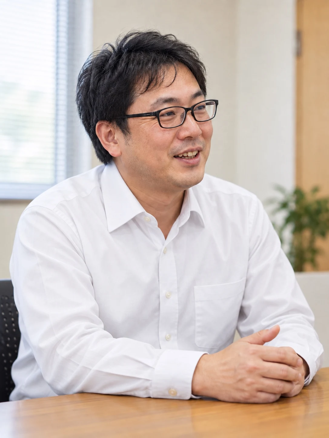 眼鏡をかけた先輩社員がインタビューに答えるイメージ